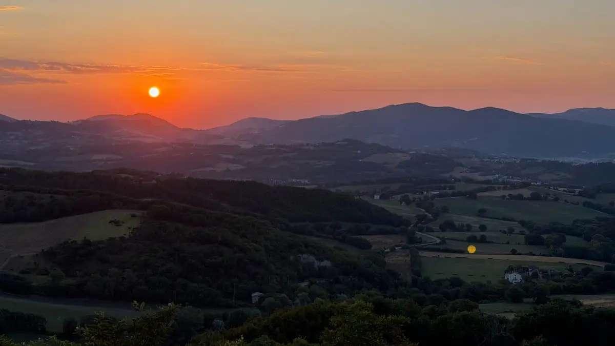 Il sole che tramonta sulla valle, nelle Marche